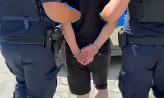 Dwaj policjanci prowadza zatrzymanego.