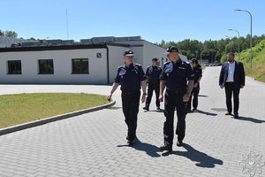 nadinsp. dr Rafał Kochańczyk - Zastępca Komendanta Głównego Policji w towarzystwie innych policjantów idzie przez teren Szkoły Policji w Katowicach.