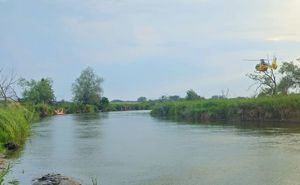 śmigłowiec LPR nad rzeką Wieprz na łodzi strażacy.