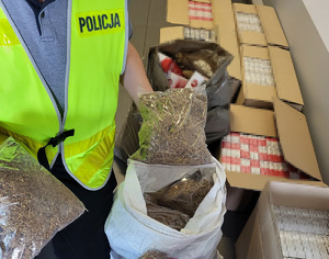 Policjant podczas oględzin zabezpieczonych papierosów i tytoniu.