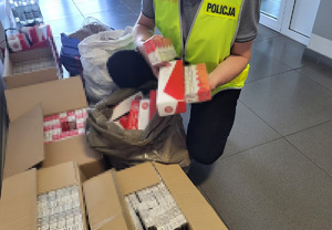 Policjant podczas oględzin zabezpieczonych papierosów i tytoniu.