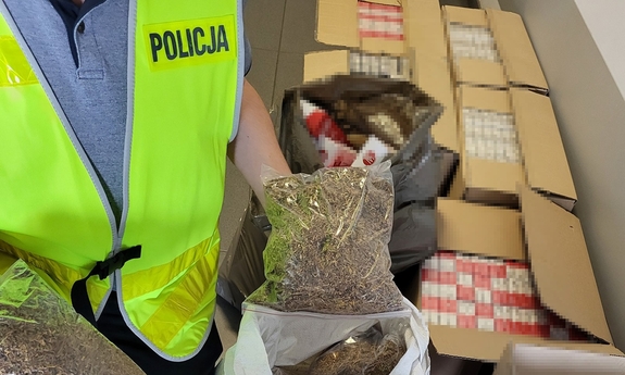 Policjant podczas oględzin zabezpieczonych papierosów i tytoniu.