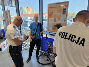 Dwaj policjanci z ujętym mężczyzną.
