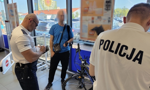 Dwaj policjanci z ujętym mężczyzną.