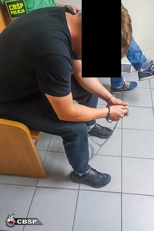Zatrzymany mężczyzna w kajdankach.