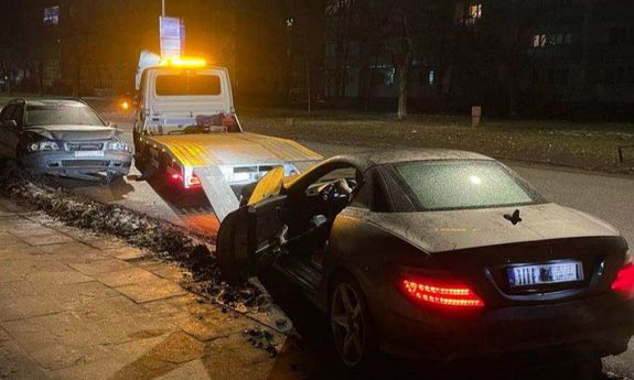 Dwa rozbite auta. Jedno z nich jest wciągane na lawetę.