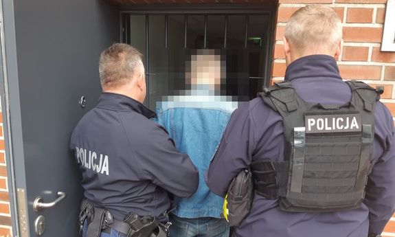 dwóch policjantów stoi z zatrzymanym.