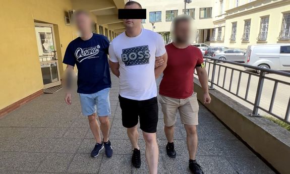 Dwaj policjanci prowadzą zatrzymanego.
