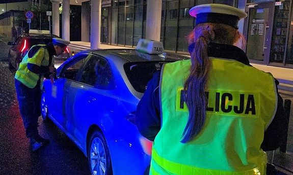 noc, policjanci sprawdzają kierowcę taksówki.