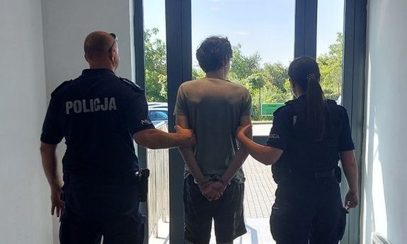 dwóch policjantów stoi z zatrzymanym.