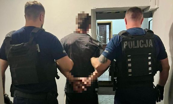 dwóch policjantów idzie z zatrzymanym.