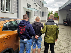 Policjanci prowadzą zatrzymanego.