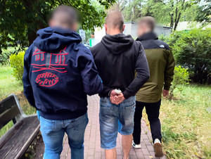 Policjanci prowadzą zatrzymanego.