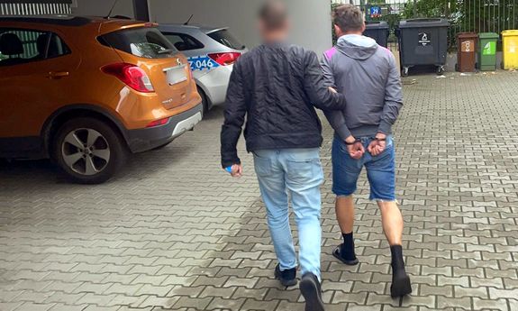 Policjanci prowadzą zatrzymanego.