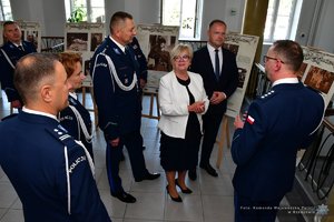 Policjanci i zaproszeni goście podczas oglądania wystawy w holu Komendy Wojewódzkiej Policji w Rzeszowie.