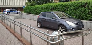 Na zdjęciu pojazd marki Hyundai , w oddali policyjny radiowóz.