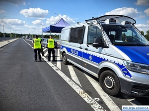 Policjanci  przy radiowozie podczas kontroli na granicy.