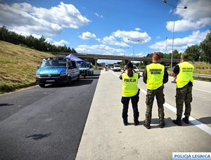 Policjantka i dwaj funkcjonariusze Straży Granicznej podczas kontroli na granicy.