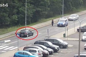 Stopklatka z monitoringu. Radiowóz na środku ulicy, naprzeciwko niego jedzie samochód.