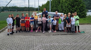 Policjant pozuje do zdjęcia z grupą dzieci.