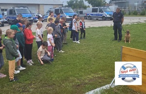 Policjant z psem służbowym podczas spotkania z dziećmi.