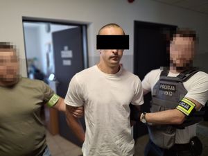 Dwaj policjanci z zatrzymanym mężczyzną.