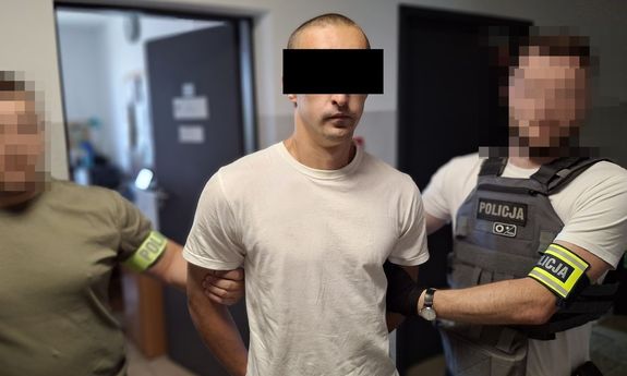 Dwaj policjanci z zatrzymanym mężczyzną.