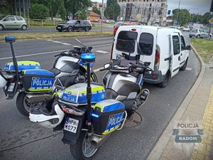 Policyjne motocykle stojące za samochodem.
