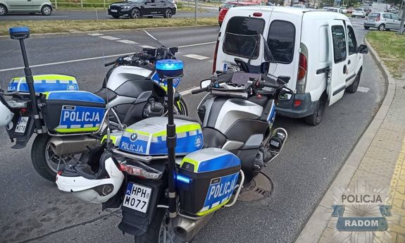 Policyjne motocykle stojące za samochodem.