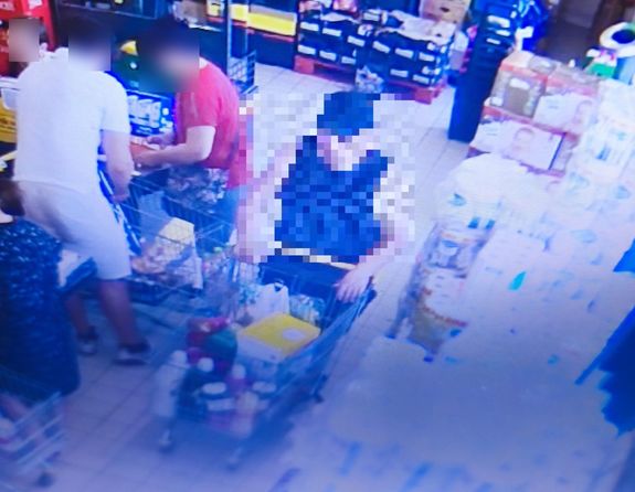 Zdjęcie z monitoringu na którym widać wnętrze supermarketu, a w nim m.in.mężczyznę z wózkiem. Jego wizerunek jest zablurowany.