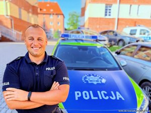 Policjant przy radiowozie.