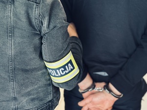 Zatrzymany prowadzony przez policjanta.