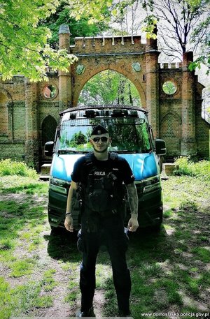 Policjant przed radiowozem.