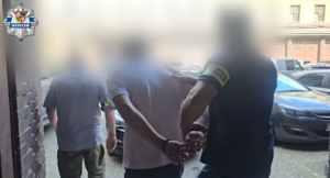 Policjanci prowadzą zatrzymanego.