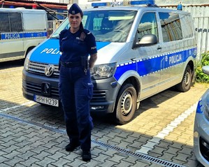Umundurowana policjantka przy radiowozie.