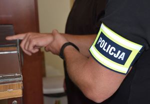 Policjant pobiera od mężczyzny odciski palców.