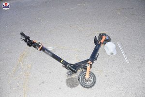 Leżąca hulajnoga i kask.