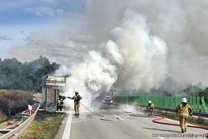 Strażacy gaszą płonące auto na autostradzie.