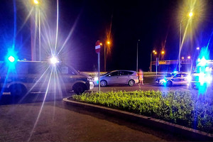 Radiowozy policyjne i samochód sprawcy i policjanci na drodze.
