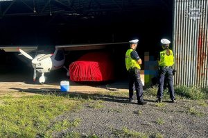 Na zdjęciu policjanci przy hangarze.