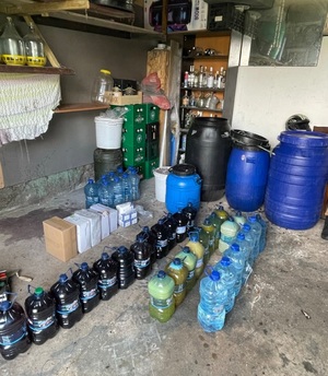 Beczki plastikowe oraz plastikowe butelki z alkoholem.