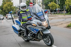 Zdjęcie przedstawia funkcjonariusza Policji pełniącego służbę na motocyklu