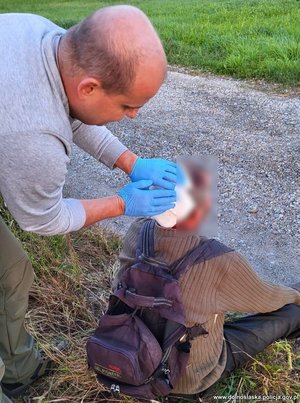 Policjant udziela pomocy mężczyźnie