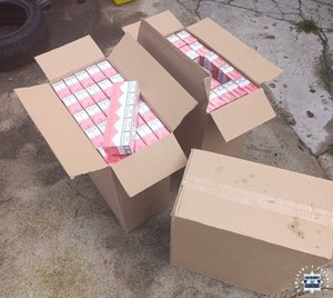 Zabezpieczone przez policjantów paczki papierosów w kartonie.
