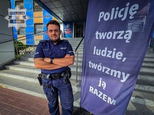 St. asp. Michał Tomanek stoi przed budynkiem komendy Policji.
