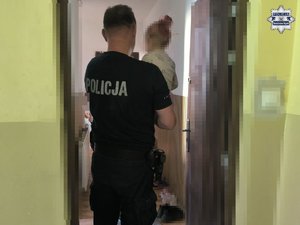 Policjant z małym dzieckiem na rękach.