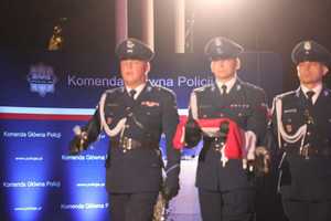 policjanci niosący flagę państwową