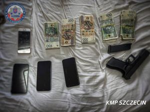 Zabezpieczone przez policjantów telefony komórkowe, broń i pieniądze.