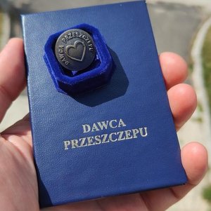Legitymacja dawcy przeszczepu trzymana w dłoni.