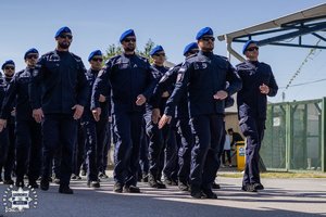 Policjanci maszerują w szyku.